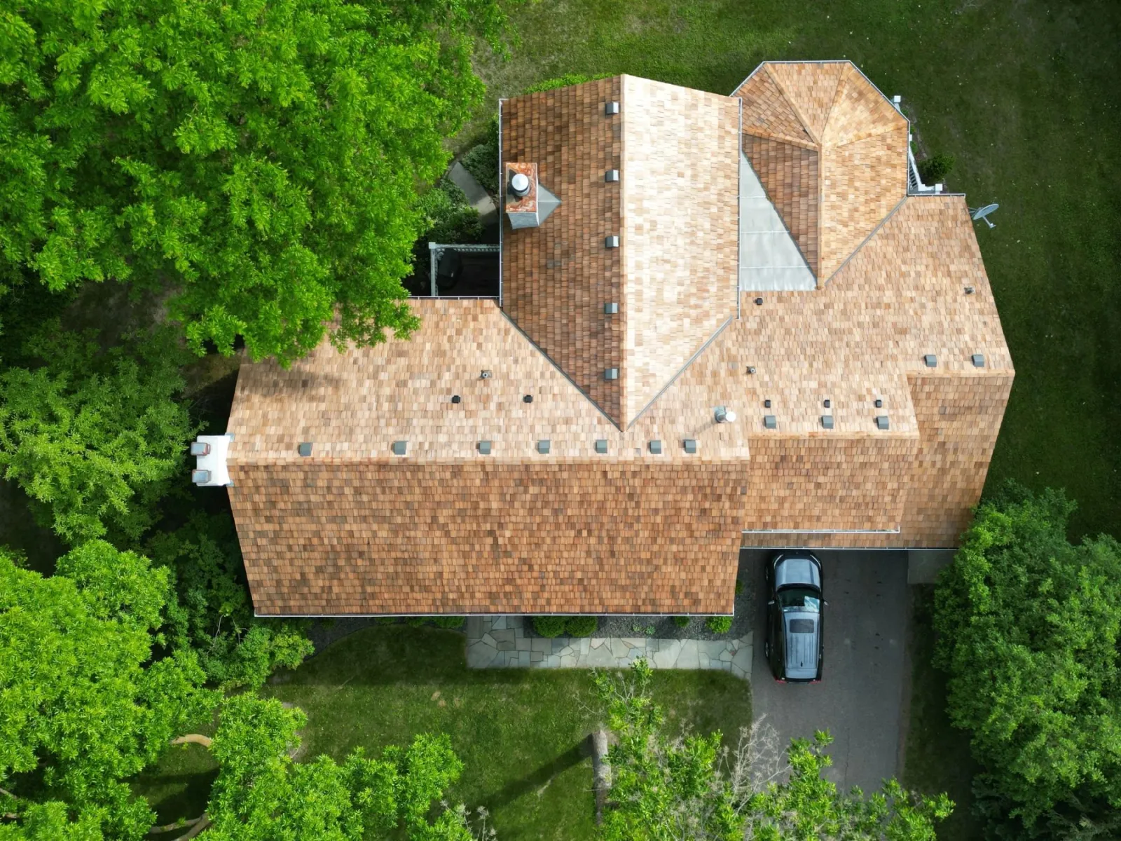 Aerial top-down view of a full cedar-shake roof and cedar shake siding