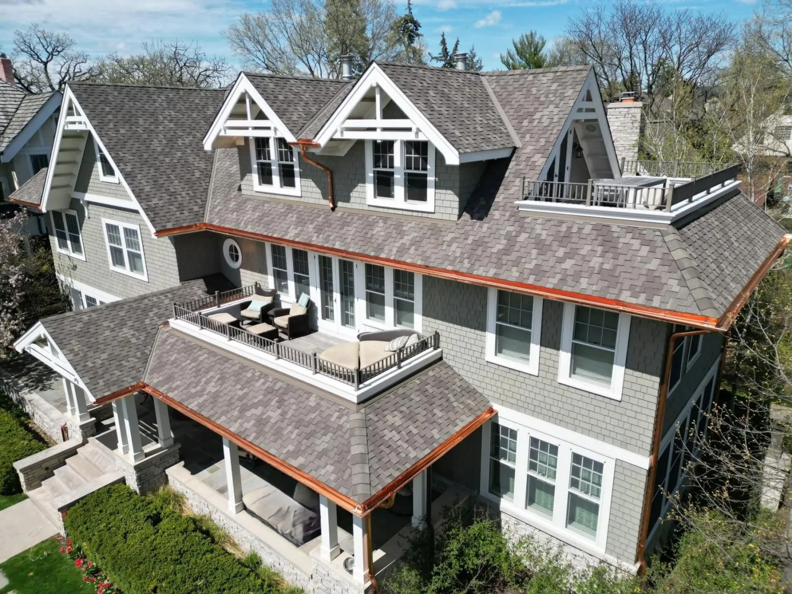 Large shingle-style home with shake siding, shingle roof and copper gutters